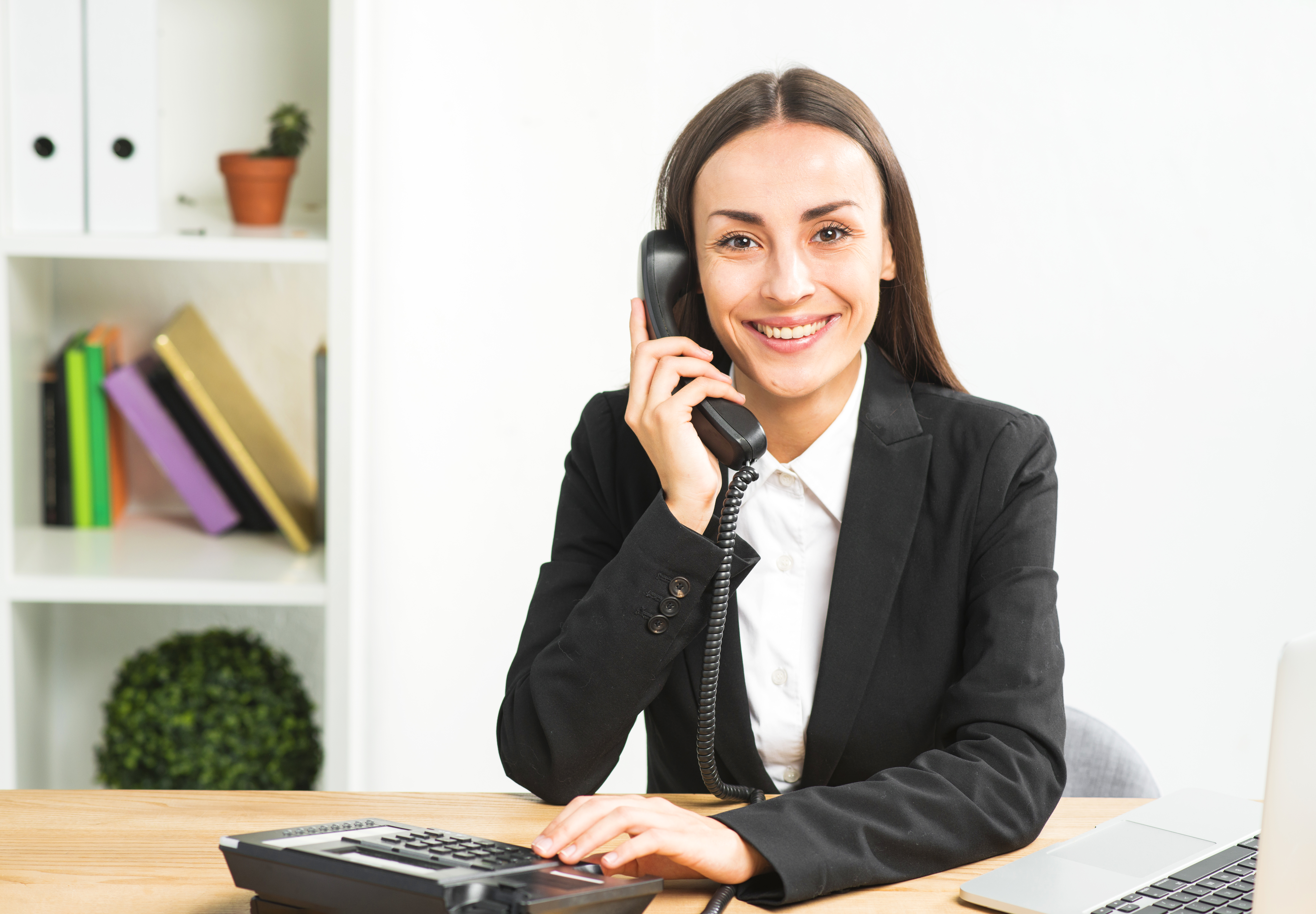 portrait-of-young-businesswoman-talking-on-telephone-looking-at-camera